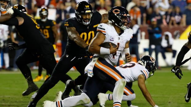 Chicago Bears quarterback Justin Fields (1) runs with the ball past Washington Commanders defensive end Montez Sweat (90) during the fourth quarter at FedExField.